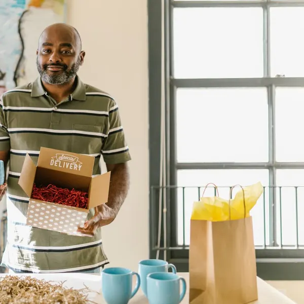A man packing mugs for delivery from his studio
